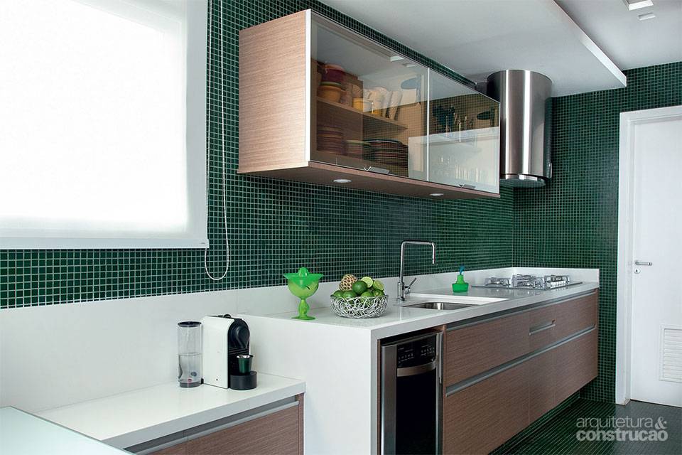 Com pastilhas de vidro do ch&atilde;o ao forro, s&oacute; este ambiente foge do branco predominante no apartamento. &ldquo;Queria dar sensa&ccedil;&atilde;o de aconchego e delimitar o espa&ccedil;o&rdquo;, explica o arquiteto Diego Revollo. O material foi escolhido por causa da praticidade, bem como o tom fechado, que disfar&ccedil;a poss&iacute;veis manchas. &ldquo;A t&eacute;cnica deaplica&ccedil;&atilde;o dessas pe&ccedil;as est&aacute; mais avan&ccedil;ada, garantindo maior fixa&ccedil;&atilde;o e fazendo delas uma op&ccedil;&atilde;o certeira.&rdquo;