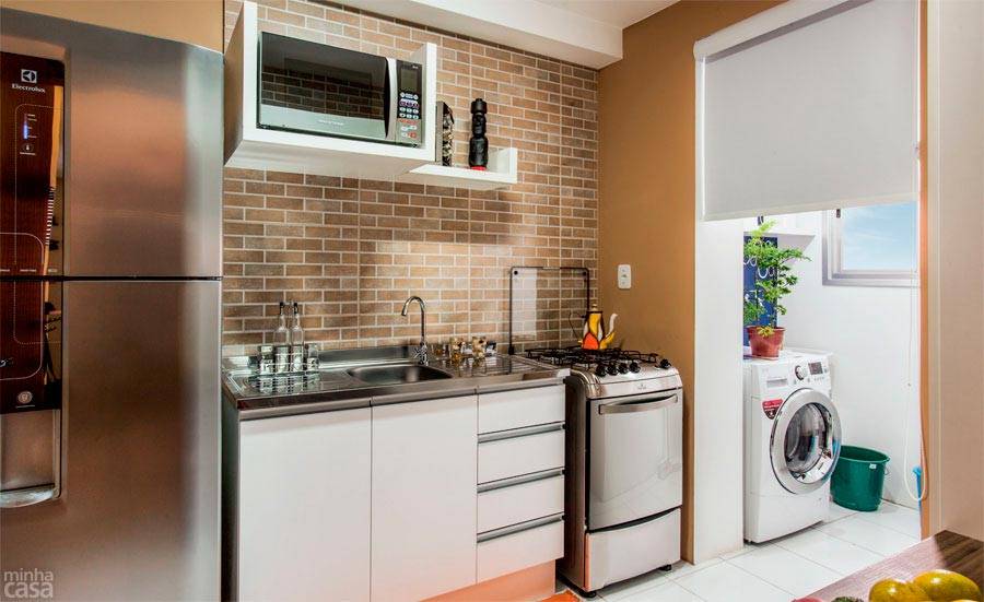 Uma dose de rusticidade foi destinada &agrave; cozinha com tom terroso e revestimento que traz &agrave; lembran&ccedil;a o tijolinho aparente. Na verdade, o acabamento comp&otilde;e-se de grandes placas cer&acirc;micas reproduzindo essa padronagem. Projeto de Let&iacute;cia Laurino Almeida.
