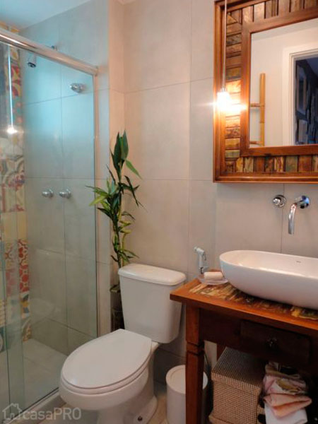 O padrão amadeirado do gabinete se repete ao redor do espelho. Projeto de Maria Helena Torres. O padrão amadeirado do gabinete se repete ao redor do espelho. Projeto de Maria Helena Torres.