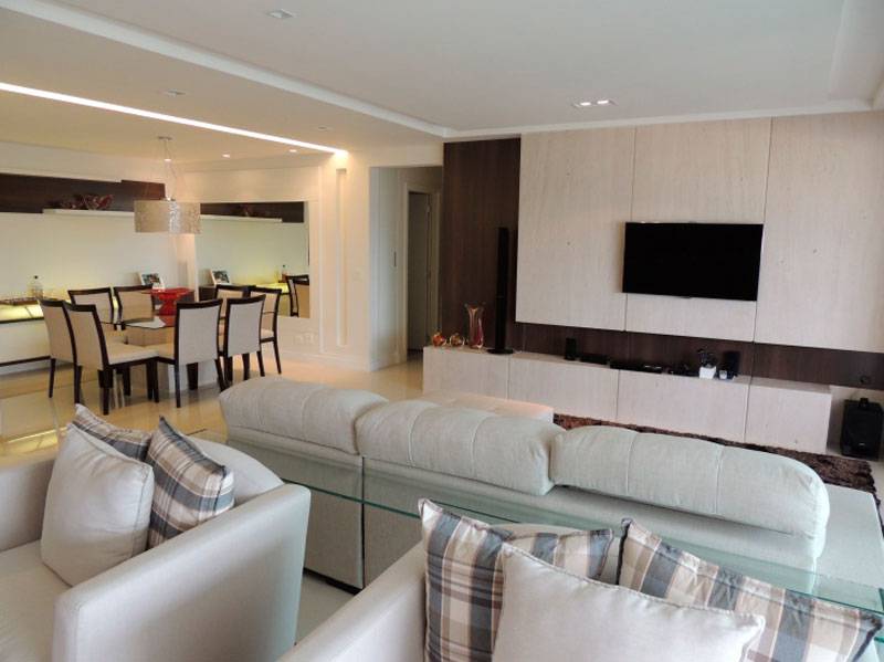 Algumas das muitas fun&ccedil;&otilde;es desta sala, de 52 m&sup2;, projetada pela arquiteta Karina Correa, s&atilde;o sala de jantar, sala de estar e home theater. A integra&ccedil;&atilde;o dos ambientes ficou por conta do mobili&aacute;rio, que segue a mesma linha nas tr&ecirc;s salas.