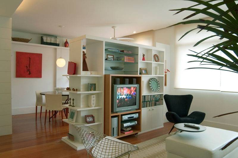 Em apenas 30 m&sup2;, &eacute; poss&iacute;vel integrar o home office, a sala de estar e a sala de jantar. &Eacute; o que prova este projeto da designer de interiores Rosaura Adiala Rosa. O espa&ccedil;o &eacute; dividido por uma estante, que divide a sala de estar da sala de jantar e esconde o home office.