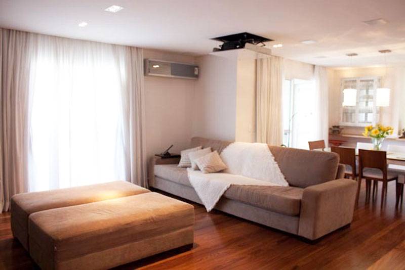 A sala de 35 m&sup2; integra a sala de jantar e o home theater com tel&atilde;o embutido. Para deixar os dois ambientes com a mesma cara, mas sem misturar suas fun&ccedil;&otilde;es, a arquiteta Beatriz Aguiar utilizou a mesma paleta de cores em todo o espa&ccedil;o.