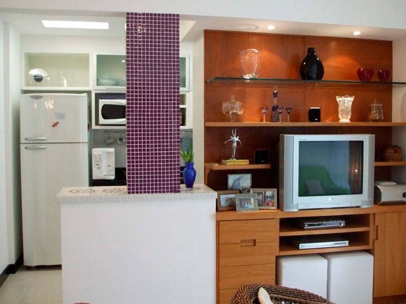 Neste espa&ccedil;o, de 40 m&sup2;, a sala de estar, a sala de TV e a cozinha foram integradas pela designer de interiores Ana Lucia Nunes Gomes. Ao demolir a parede que separava a sala da cozinha, apareceu uma coluna, que acabou servindo de destaque para a integra&ccedil;&atilde;o dos ambientes.