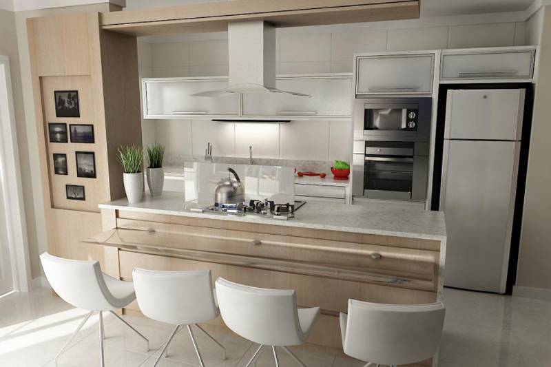 Integrada &agrave; sala, a cozinha projetada por Jean Carlos Flores possui uma grande bancada que abriga o cooktop e a &aacute;rea de refei&ccedil;&otilde;es. Repare na parte de madeira que virou um local para expor fotos.