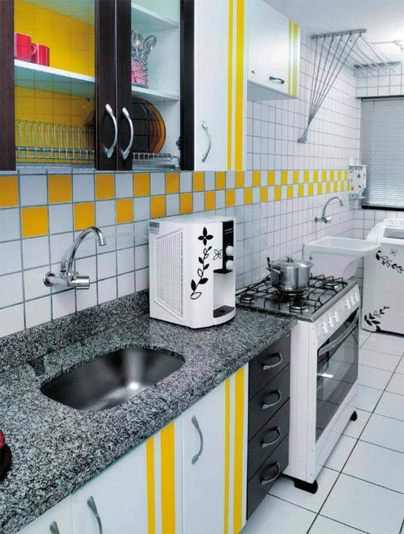 Bastaram dois rolos de adesivo vin&iacute;lico amarelo e a criatividade da moradora para mudar o visual desse ambiente em Recife - a cor aparece nos arm&aacute;rios e tamb&eacute;m na parede ao fundo, criando um mosaico colorido.