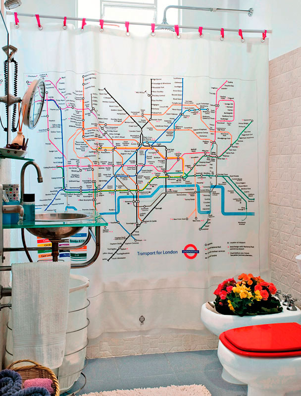Para repaginar o banheiro e fugir do quebra-quebra da reforma, a moradora optou por uma inusitada cortina pl&aacute;stica com estampa do mapa do metr&ocirc; de Londres &ndash; note que ela foi presa com fitas de cetim, no lugar das tradicionais argolas. O assento vermelho combina com o irreverente arranjo de flores no bid&ecirc;.