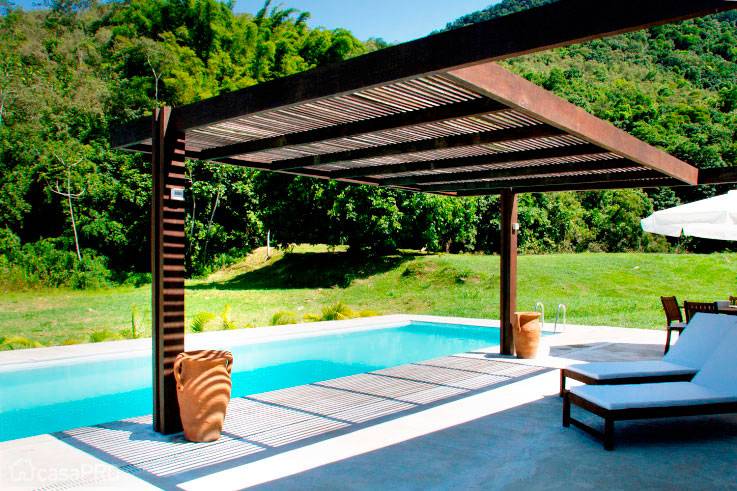 Pergolado filtra a luz, produzindo agrad&aacute;vel sombreamento sobre parte do deck da piscina. Projeto de Eliete Nemy Mour&atilde;o.