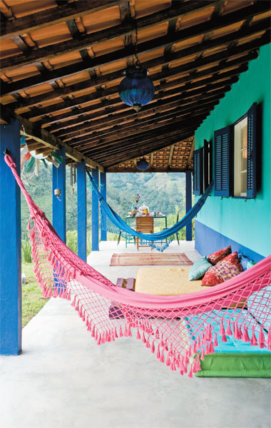 Varanda de casa de campo ganhou rede. Situado em uma casa de campo, os 30 m&sup2; desta varanda oferecem uma &aacute;rea para descanso. Redes, colchonetes e tapetes garantem o conforto e ajudam no relaxamento ao lado da vista. Quem assina o projeto &eacute; a decoradora Neza Cesar.