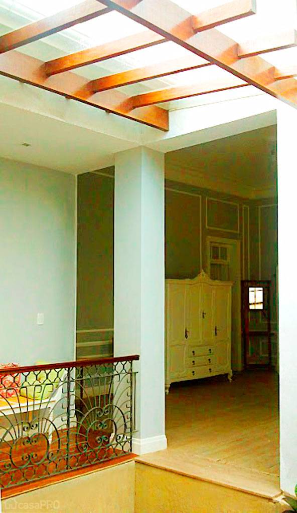 O pergolado de madeira com vidro poupa a entrada do sol no interior e circula&ccedil;&atilde;o da casa. Projeto de Izabela Melo.