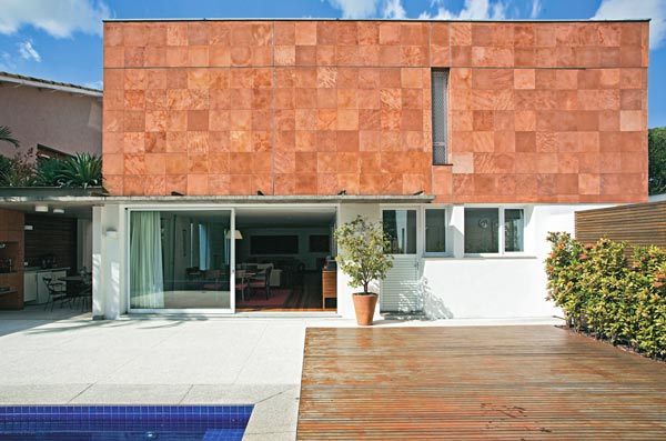 Casa dos anos 70 é atualizada com pedra, vidro e madeira