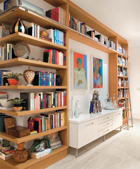 Prateleiras at&eacute; o teto comp&otilde;em a biblioteca deste apartamento, decorado pel...
