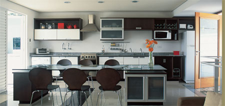 9 m&sup2;: Tr&ecirc;s conceitos em um recurso: erguer uma casa moderna, funcional e econ&ocirc;mica . Tudo isso sintetizado na integra&ccedil;&atilde;o dos espa&ccedil;os. Dispensamos paredes e portas e seus desmembramentos: massa, pintura e rodap&eacute;s, diz o arquiteto Guilherme Mattos, de Mogi das Cruzes, SP. Sobrou or&ccedil;amento, ent&atilde;o, para o jovem casal investir nos bons acabamentos. Preto e prata se valorizam mutuamente, e na presen&ccedil;a do branco criam contrastes suaves e elegantes, afirma Guilherme. No piso de porcelanato bege, um desenho com placas negras forma um tapete para a mesa, que ainda serve de bancada e divisor de ambientes.