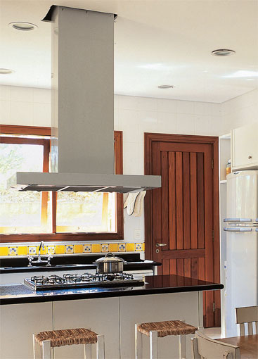 26 m&sup2;: Planejada especialmente para os lanches das crian&ccedil;as, a copa desta casa de campo em Itu, no interior paulista, tamb&eacute;m beneficia os adultos, que mant&ecirc;m os amigos pr&oacute;ximos durante o preparo das refei&ccedil;&otilde;es. A conviv&ecirc;ncia era o mote do projeto, diz a arquiteta Andrea Carla Dinelli, de S&atilde;o Paulo. Ela temperou a predomin&acirc;ncia de preto (bancadas de granito) e branco (revestimentos cer&acirc;micos e laminado) com caixilhos de madeira garapeira e uma faixa de azulejos pintados a m&atilde;o pela propriet&aacute;ria, artista pl&aacute;stica.