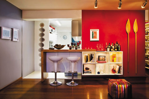 Com pouco espa&ccedil;o, este ambiente integrado foi projetado com foco no conv&iacute;vio social. A bancada bicolor com folhas de MDF recebe um tampo laminado. Com as mesmas cores do piso e do m&oacute;dulo da sala, esta pe&ccedil;a branca ajuda a interligar os ambientes. Projeto de Neto Porpino.