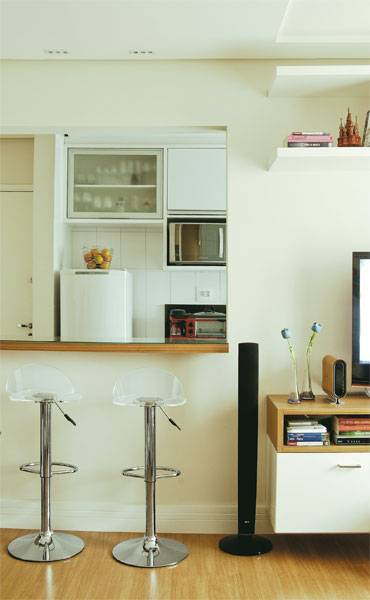 Com 36 m&sup2;, este apartamento precisa de espa&ccedil;o. A sensa&ccedil;&atilde;o de amplitude &eacute; gerada pela integra&ccedil;&atilde;o dos ambientes, feita pela bancada. Revestida com uma l&acirc;mina de madeira, ela recebe uma placa de vidro, que &eacute; f&aacute;cil de limpar. A transpar&ecirc;ncia segue na decora&ccedil;&atilde;o com as banquetas de acr&iacute;lico.