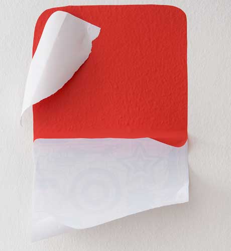 Comece aplicando o quadrado maior. Descole apenas uma parte do adesivo e pres...