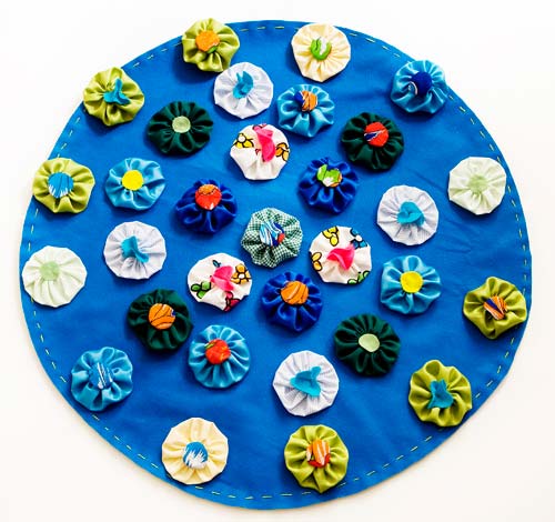 Aplique os fuxicos no tapete com cola quente.