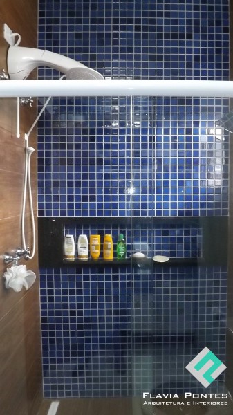 No lavabo de 3,5 x 1,4 m, projetado pela arquiteta Flávia Pontes para uma residência em Poços de Caldas (MG), as pastilhas cerâmicas azuis, da Atlas, dialogam com o piso e as laterais do box, ambos em porcelanato Vilagres, na cor jatobá. A arquiteta optou pelo piso mais escuro na área do box, já que o espaço suja muito. Dentro do box, há uma janela, de 80 x 60 cm, que faz a ventilação do ambiente.