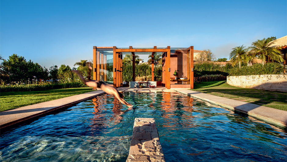 A piscina é o convidativo ponto de ligação entre a residência e o anexo