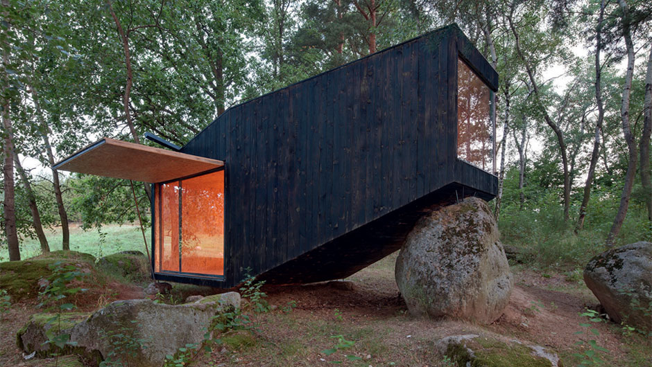 Cabana em floresta remota da República Tcheca se apoia em pedra