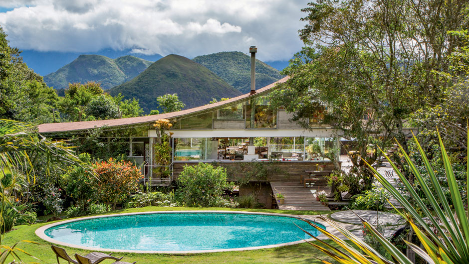 Casa na serra ostenta telhado curvo, amparado por treliças metálicas