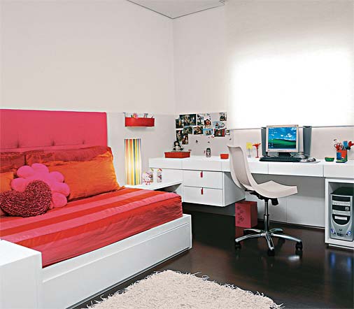 Para a irmã mais nova, de 7 anos, o arquiteto Toninho Noronha seguiu os mesmos moldes do quarto anterior: cama com bicama, bancada de estudo, paredes revestidas a meia altura de madeira laqueada e módulos para guardar roupas e brinquedos. "Mudei apenas as cores: rosa e laranja, conforme o pedido da caçula", lembra. Na cabeceira, de 75 cm de altura, um toque inusitado: a lycra forra o painel de madeira e espuma.