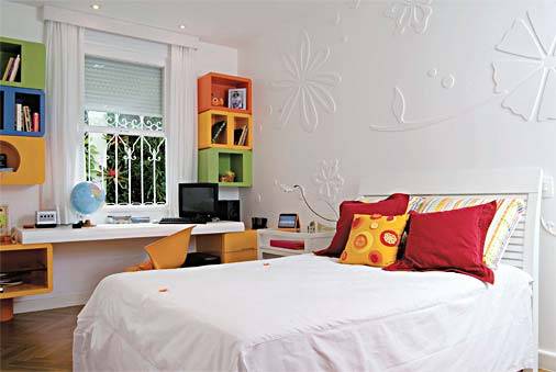 Feminino e charmoso, mas nada excessivamente rom&acirc;ntico. Era assim que a garota de 13 anos queria seu quarto de 13,25 m&sup2;. "Coloquei flores de poliuretano em relevo nas paredes e pintamos todas de branco", explica a arquiteta Andr&eacute;a Chicharo. De modo a aproveitar melhor o espa&ccedil;o, a bancada de estudos ficou encostada em frente &agrave; janela. Nichos laqueados de diversas formas e tons foram fixados na alvenaria e guardam livros e objetos decorativos. Almofadas lisas, listradas e bordadas destacam-se sobre a colcha branca.
