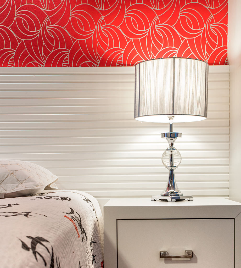 Papel de parede vermelho é a estrela deste quarto de casal