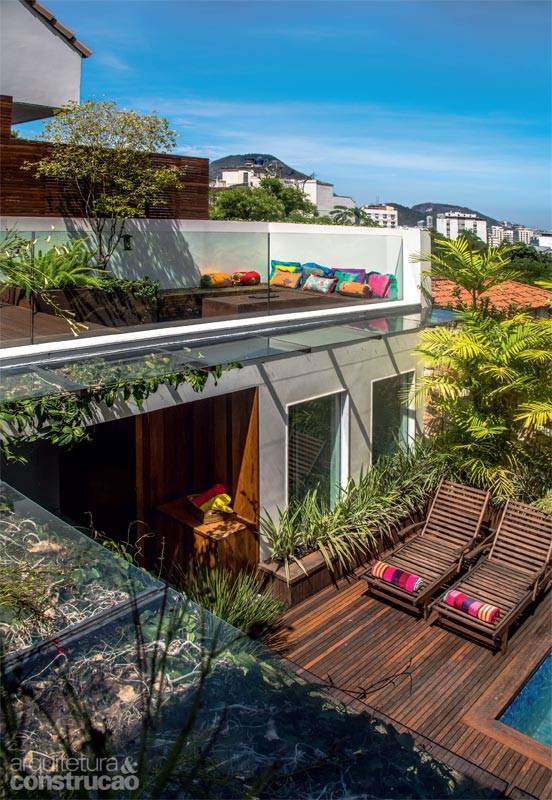 Sob medida para proteger a varanda, o beiral de 80 cm foi montado com vidro laminado incolor (10 mm) e apoiado em estrutura de alum&iacute;nio com acabamento de a&ccedil;o corten (se&ccedil;&otilde;es de 1 m, execu&ccedil;&atilde;o da Bergel). Cabos de a&ccedil;o encapados servem de guia para a trepadeira sapatinho-de-judia. Almofadas da Lisa Corti. Projeto do arquiteto Erick Figueira de Mello.