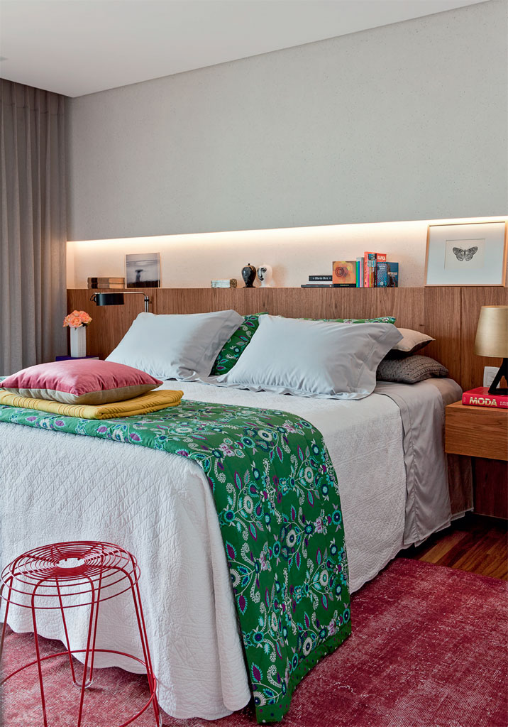 O desejo de Carolina era ter um quarto de linhas contempor&acirc;neas e nuances acinzentadas, sem esquecer o aconchego. Planejando o m&iacute;nimo de interfer&ecirc;ncias no ambiente de 17 m&sup2;, a designer de interiores Luciana Penna, autora do projeto em S&atilde;o Paulo, sugeriu uma pe&ccedil;a &uacute;nica de marcenaria, com criados-mudos suspensos num painel atr&aacute;s da cama. &ldquo;Acima da cabeceira de freij&oacute;, constru&iacute; uma parede de gesso para criar um nicho, que abriga livros, esculturas e quadros. Elegi a ilumina&ccedil;&atilde;o indireta, o que refor&ccedil;a o clima intimista&rdquo;, explica.