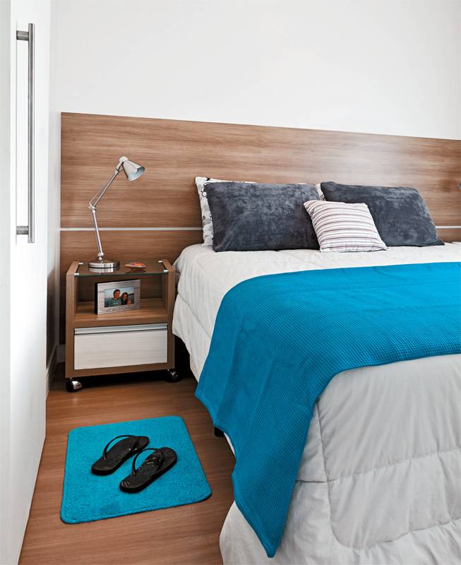 No quarto, pain&eacute;is de MDF no padr&atilde;o am&ecirc;ndoa (2,75 x 0,65 m cada) cumprem a fun&ccedil;&atilde;o de cabeceira. As placas foram cortadas e fixadas diretamente na alvenaria criando esta atmosfera aconchegante no ambiente de dormir.
