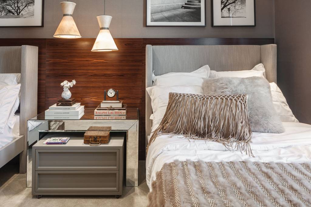 O quarto da arquiteta Andrezza Alencar &eacute; um c&ocirc;modo feito para viajar! A inspira&ccedil;&atilde;o deste ambiente, segundo a profissional, veio de um hotel nos Alpes su&iacute;&ccedil;os. "Procurei trabalhar materiais mais quentes - como peles de coelho, tricots, couro e madeira escura -, para trazer aconchego e sofistica&ccedil;&atilde;o ao ambiente. A escolha do mobili&aacute;rio e dos acabamentos foi bem criteriosa, pois precisava unir o sofisticado a um ambiente funcional e pr&aacute;tico. Em uma das paredes colocamos um papel de parede franc&ecirc;s que imita um couro de croco (pr&aacute;tico para limpeza, al&eacute;m de ter uma textura maravilhosa). Na parede oposta, um painel de madeira pau-ferro, dando fundo para o linho utilizado na cabeceira, mostra que esse quarto foi projetado para ser exclusivo para o h&oacute;spede, em um hotel ou mesmo dentro da sua casa", diz Alencar.