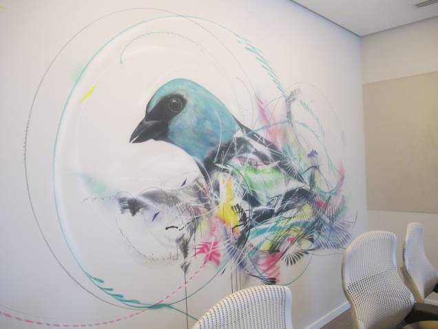 Pintura de um pássaro, símbolo da empresa, em uma das salas de reunião. A obra lembra os grafites espalhados pelas ruas de São Paulo. Pintura de um pássaro, símbolo da empresa, em uma das salas de reunião. A obra lembra os grafites espalhados pelas ruas de São Paulo.