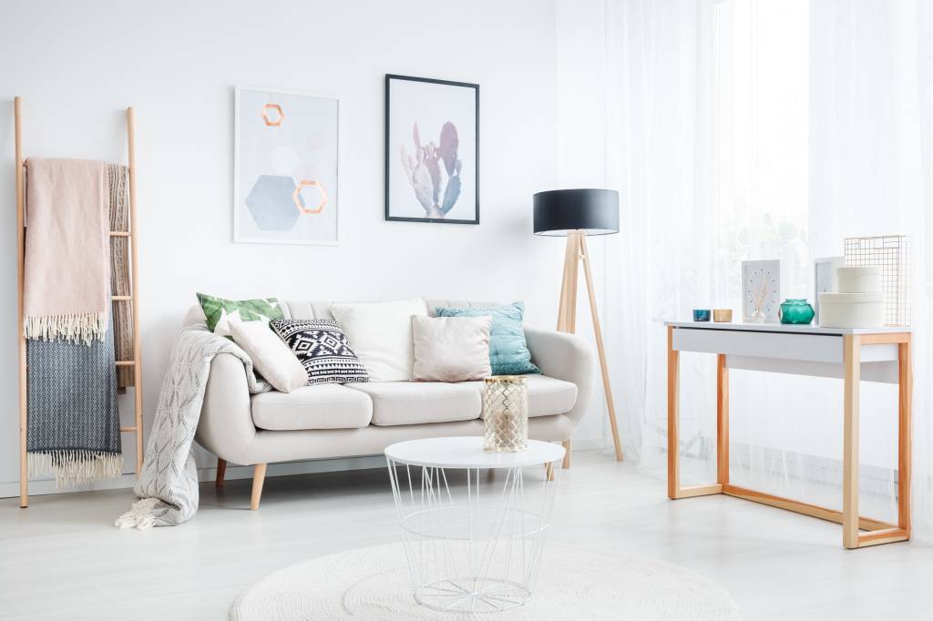 sala de estar com tons neutros, almofadas com estampas diferentes e dois quadros na parede sala de estar com tons neutros, almofadas com estampas diferentes e dois quadros na parede