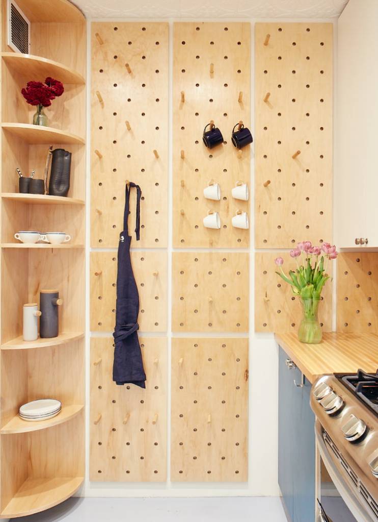 estante de madeira com objetos, parede com pegboards com xícaras penduradas estante de madeira com objetos, parede com pegboards com xícaras penduradas