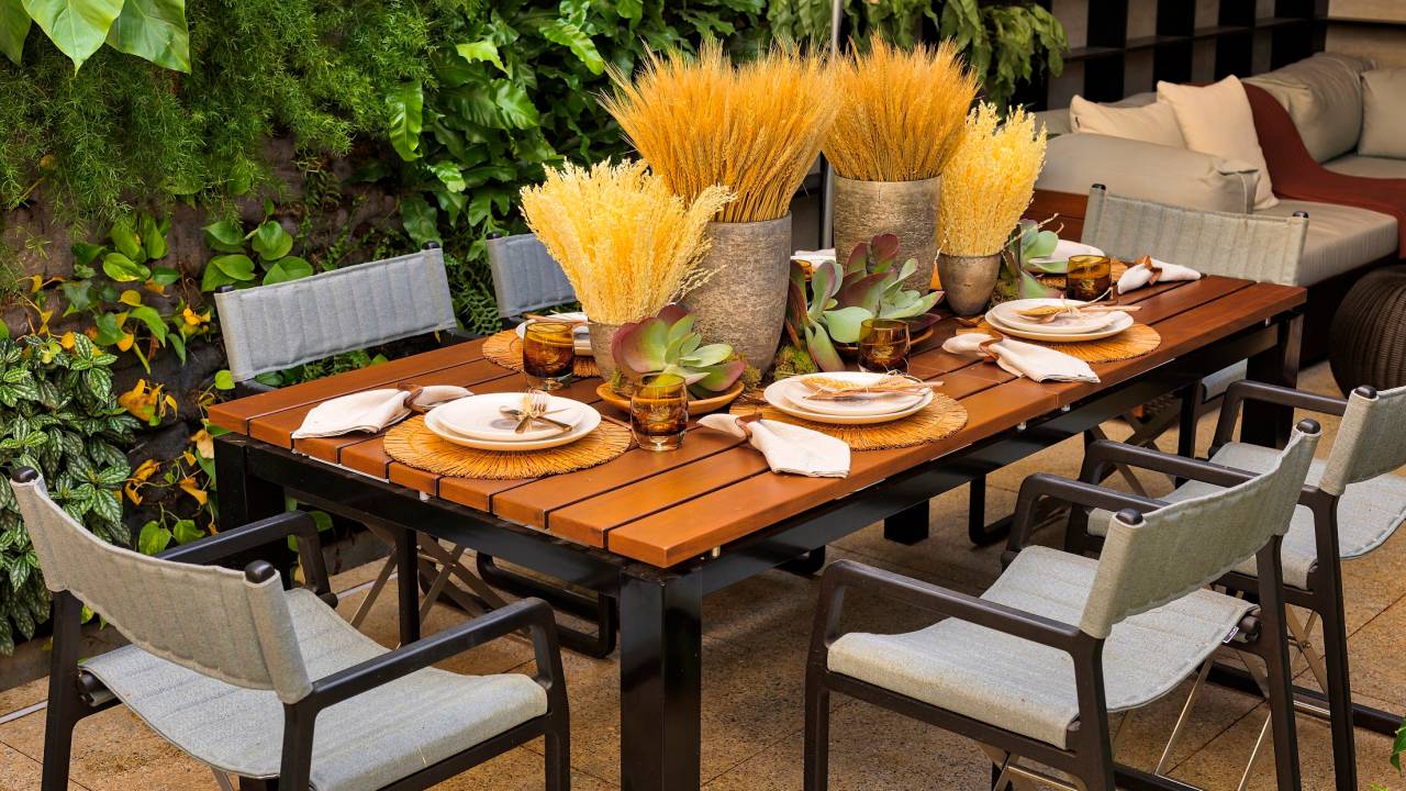 área externa com mesa posta e parede com plantas