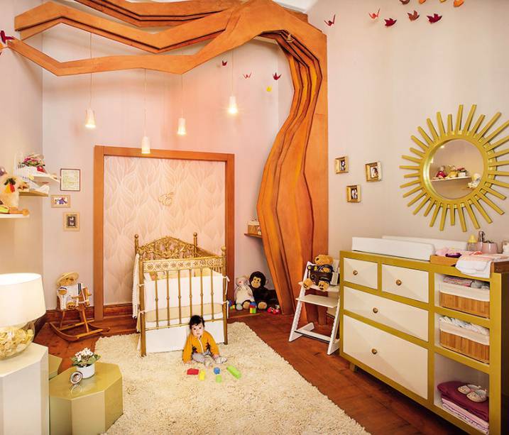 Este ambiente acolhedor &eacute; inspirado na &eacute;poca colonial, trazendo uma vers&atilde;o atual para o estilo marcado pelas cores chamativas, como o dourado e os alaranjados. O ber&ccedil;o, por exemplo, &eacute; todo em bronze, protegido sob uma esp&eacute;cie de pergolado que simboliza uma &aacute;rvore e enfatiza a verticalidade do ambiente. J&aacute; branco ameniza a composi&ccedil;&atilde;o e afirma a contemporaneidade. Quarto de Emilia - Natalia Zapata Talavera e Daniella Larrabure Terry. CASACOR Peru.