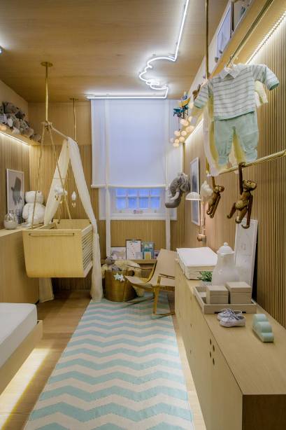 Os 10 m&sup2; foram bem resolvidos com solu&ccedil;&otilde;es modernas, no projeto de clima vintage, meio escandinavo, meio brasileiro. O ber&ccedil;o &eacute; do tipo balan&ccedil;o, enquanto a cama de apoio &eacute; retr&aacute;til para otimizar o espa&ccedil;o. A ilumina&ccedil;&atilde;o, assinada por Leila Dionizio, se destaca pelo neon que forma uma nuvem no teto. Design de Ninar - Leila Dionizio. CASACOR Rio de Janeiro.