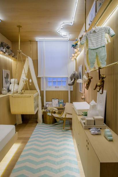 Os 10 m&sup2; foram bem resolvidos com solu&ccedil;&otilde;es modernas, no projeto de clima vintage, meio escandinavo, meio brasileiro. O ber&ccedil;o &eacute; do tipo balan&ccedil;o, enquanto a cama de apoio &eacute; retr&aacute;til para otimizar o espa&ccedil;o. A ilumina&ccedil;&atilde;o, assinada por Leila Dionizio, se destaca pelo neon que forma uma nuvem no teto. Design de Ninar - Leila Dionizio. CASACOR Rio de Janeiro.