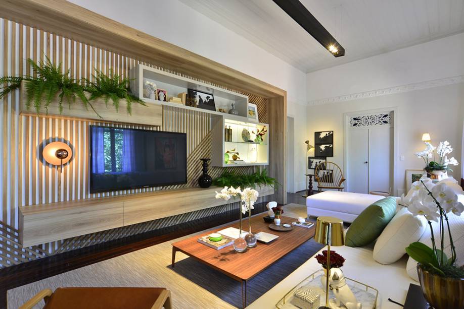 A proposta do designer de interiores Andr&eacute; Monte &eacute; uma sala multiuso: com TV, jogos e lounge. Tons suaves, madeiras e tecidos naturais garantem a eleg&acirc;ncia, pontuados com detalhes metalizados em ouro e cobre, que s&atilde;o tend&ecirc;ncia. Repare na ilumina&ccedil;&atilde;o, pensada para n&atilde;o alterar o desenho do forro original.
