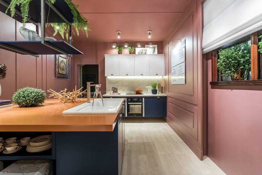 A arquiteta Flavia Bonet buscou inspiração na união da família e em referências de moda para criar esta Cozinha na Casa Cor Paraná. O terracota, o azul jeans, o branco, o rosa antigo transitam das passarelas para a arquitetura. A cuba foi inserida na bancada no mesmo tom do famoso tecido da Hermès, que destaca a ilha onde os convidados fazem sua refeição e conversam ao redor.