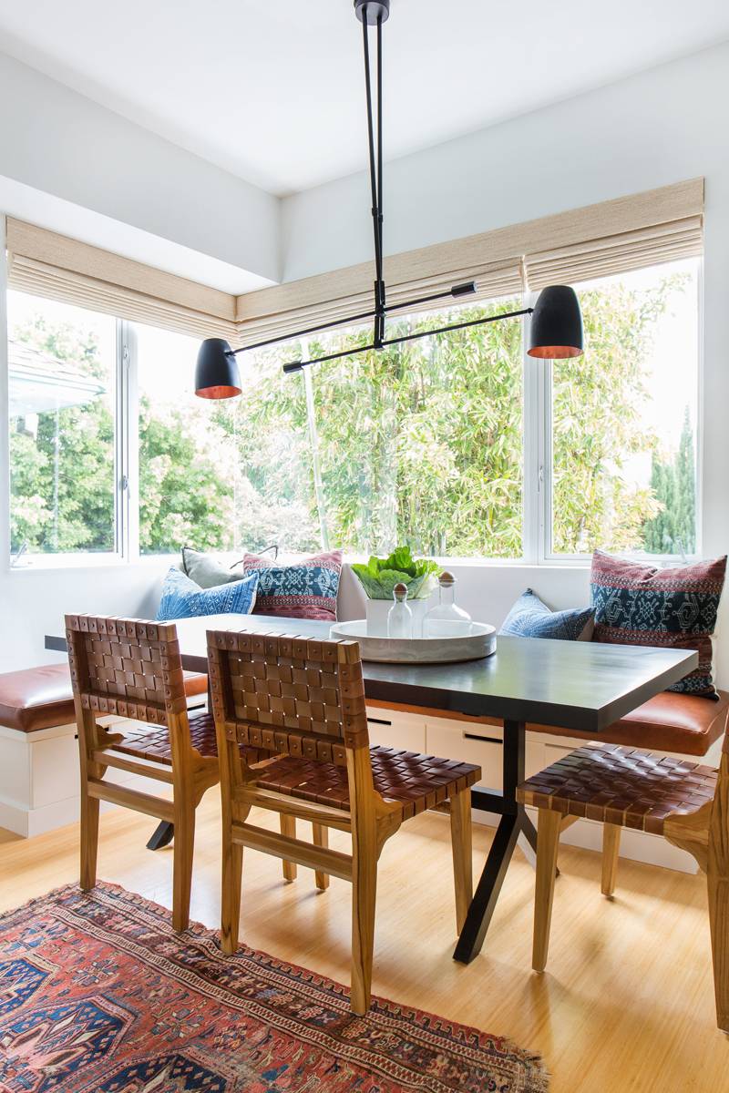 Amber Interiors projetou esta sala de jantar, com banco, cadeiras com trama em couro e lumin&aacute;rias modernas.