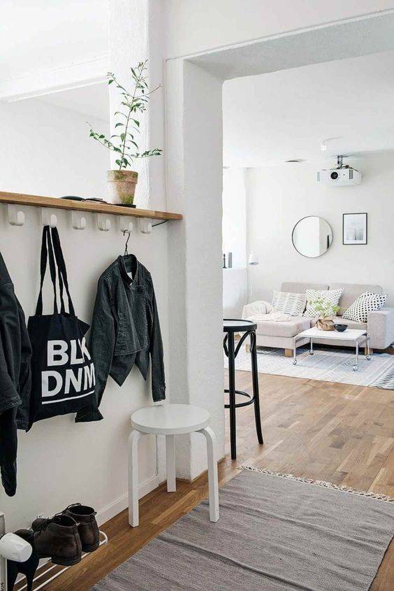 O ch&atilde;o em madeira e os m&oacute;veis neutros d&atilde;o tom clean a sala de estar. Bolsas, jaquetas, sapatos e ecobags t&ecirc;m um cantinho reservado logo na entrada.