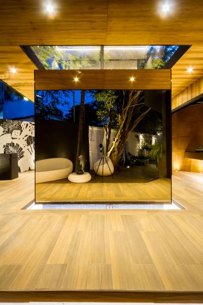 <strong>Baño: Reflex Box</strong> –Hebert Vargas e Nataly Dorado. Ao centro da plataforma em madeira, surge um espelho de água. Sobre ele, foi posicionado um cubo espelhado que dá a sensação de estar flutuando – a caixa de reflexos do projeto. No alto, a abertura revela a vegetação que envolve o espaço. A proposta é de valorizar linhas simples e formas puras geométricas, em um espaço livre de barreiras visuais, com 67 m<span>²</span>.