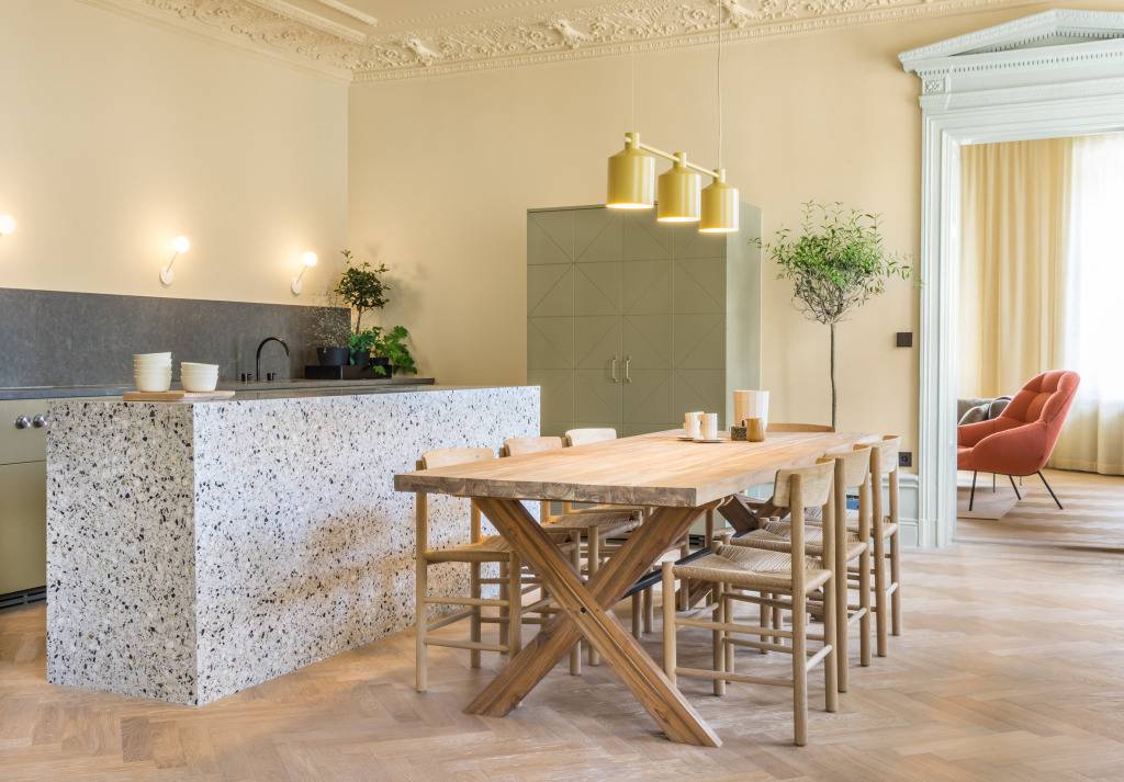 Na reforma desta cozinha, os adornos neocl&aacute;ssico foram mantidos, mas ganharam um belo toque de modernidade cobertos por tons pastel. O mobili&aacute;rio em madeira e a bancada em granito contribuem para a atmosfera descontra&iacute;da. O projeto foi concebido pelo Note Design Studio