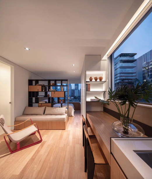 O desafio do plano compacto e estreito de 32 m² foi resolvido com a eliminação da varanda, incorporando-a ao apartamento para ganhar mais espaço e criar integração de maneira linear. Uma linha contínua de carpintaria foi projetada para otimizar ainda mais os espaços, com diferentes usos – a superfície da cômoda se estende e se transforma em armário, mesa e bancada da cozinha. O desafio do plano compacto e estreito de 32 m² foi resolvido com a eliminação da varanda, incorporando-a ao apartamento para ganhar mais espaço e criar integração de maneira linear. Uma linha contínua de carpintaria foi projetada para otimizar ainda mais os espaços, com diferentes usos – a superfície da cômoda se estende e se transforma em armário, mesa e bancada da cozinha.