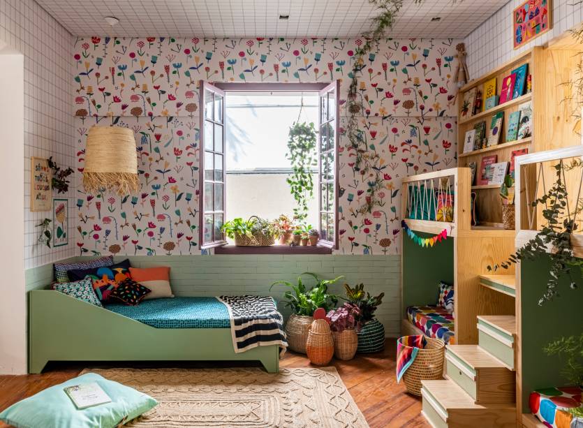 Sala de Leitura - Hana Lerner Rosalen, Mooui e Fustta. O lúdico reina neste espaço que abre portas para a imaginação. O ambiente de 13 m² remete ao encanto das antigas bibliotecas, o trabalho especial em marcenaria garante um mezanino e passagens secretas - é por aqui o acesso à casinha na árvore do quintal. Um livro gigante, moldado em folhas de madeira e com páginas personalizadas por adesivos, promete divertir pais e filhos.