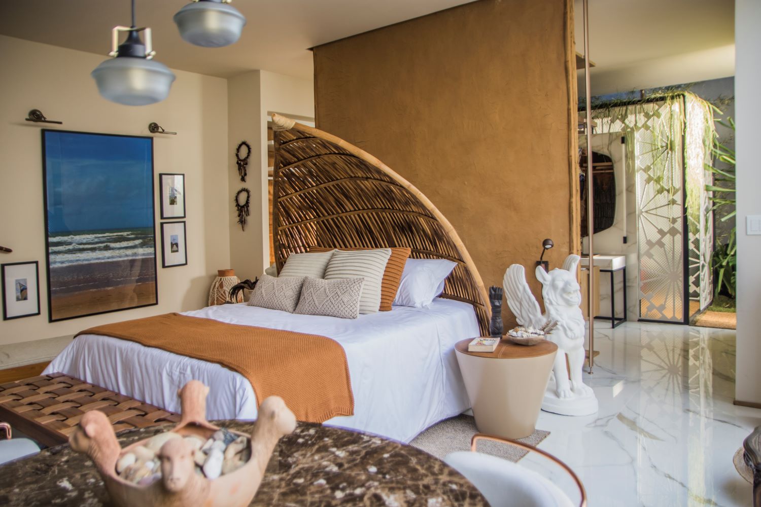 Ref&uacute;gio Trancoso - Mila Liberato. Uma ampla su&iacute;te de casal &eacute; equipada com sala de banho e closet integrado. A arquitetura vernacular, o artesanal e o feito &agrave; m&atilde;o s&atilde;o valorizados no projeto, com a combina&ccedil;&atilde;o de elementos. A simplicidade d&aacute; o tom do ambiente, sem deixar a sofistica&ccedil;&atilde;o de lado.