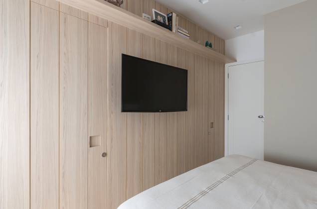 O painel em marcenaria de acabamento CIPRES, da Guararapes, esconde o banheiro da suíte e um pequeno closet, logo de entrada. O painel em marcenaria de acabamento CIPRES, da Guararapes, esconde o banheiro da suíte e um pequeno closet, logo de entrada.