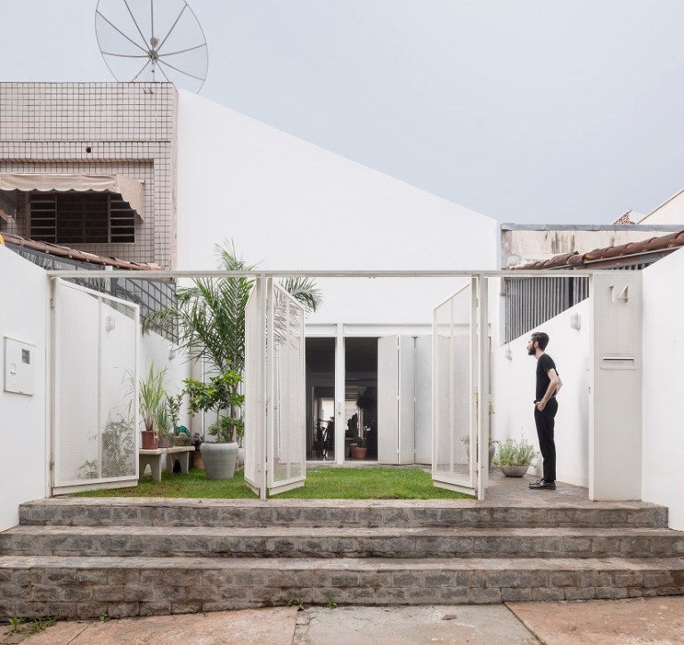 Casa ganha jardim e varanda no lugar de garagem com muros